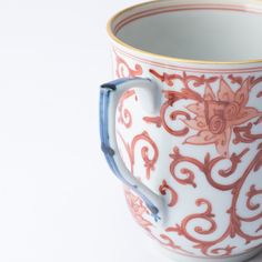 an ornately decorated coffee cup with blue handles