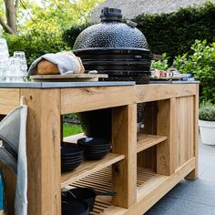 an outdoor bbq with pots and pans sitting on it's side table