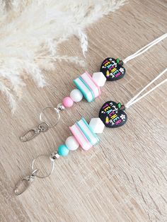 three candy lollipops are sitting on top of a wooden table next to some feathers