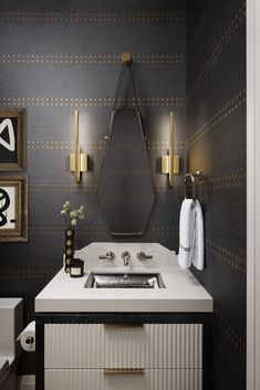 a white sink sitting under a mirror next to a wall mounted faucet in a bathroom