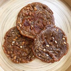 three cookies with nuts are on a plate