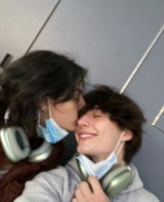 two people with headphones are kissing each other