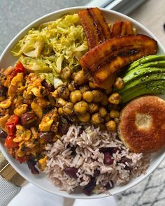 a white bowl filled with rice, beans and other foods on top of a table