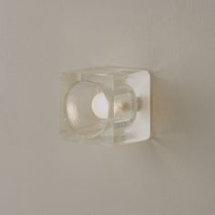 a light that is on the side of a wall with a glass block in it