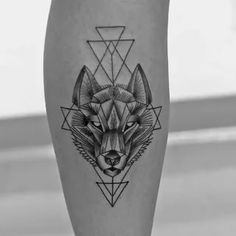 a black and white photo of a tattoo design on the leg, with an image of a wolf's head