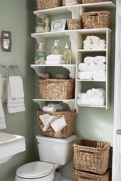 Organized bathroom with woven baskets and neatly rolled towels on shelves. Bathroom Storage Over Toilet Cabinet Towel Racks, Rustic Above Toilet Storage, Bathroom Storage Shelf Rustic, Teen Barhroom Storage, Creative Bathroom Storage Ideas, Clever Bathroom Storage, Tiny Powder Room, Bathroom Storage Over Toilet Ladder Under $100, Over The Toilet Cabinet