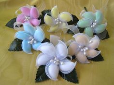 four different colored hair bows with leaves and pearls