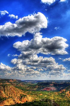 the sky is filled with clouds over some mountains