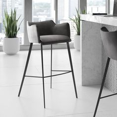 two black and white bar stools in front of a counter with potted plants