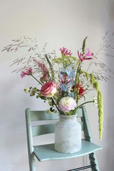 a vase filled with flowers sitting on top of a blue chair