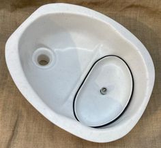 a white porcelain sink with two holes in it