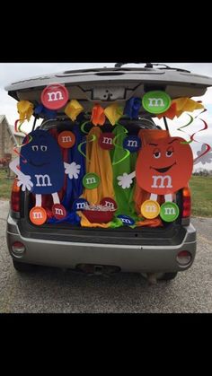 the back end of a car decorated with paper cutouts and decorations for m & m's