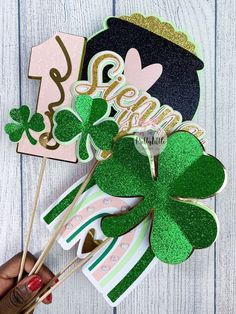 st patrick's day cake topper and shamrock lollipop picks on a white wooden table