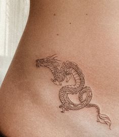 a woman's stomach with a dragon tattoo on it