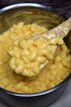 a ladle full of macaroni and cheese with the words stovetop mac and cheese