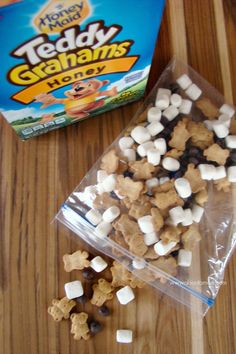 there is a bag of teddy grahams next to the box of treats on the table