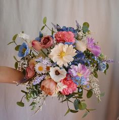 a woman holding a bouquet of flowers in her hand