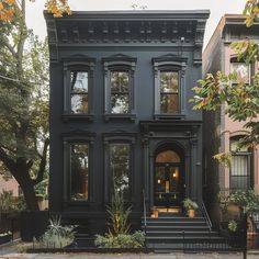 a black house with lots of windows on the front and stairs leading up to it