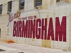 a large brick wall with the words birmingham painted on it's side in red and yellow