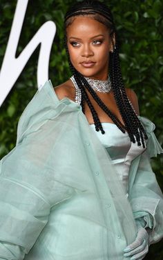 a woman with long braids wearing a green dress