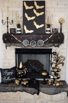 a fireplace decorated for halloween with gold and black decorations on the mantle, candles, and other items