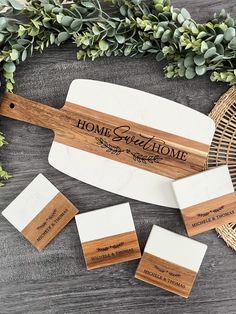 three wooden business cards with the words home sweethome on them next to some greenery