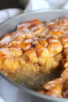 cinnamon buns in a pan with icing drizzled over them