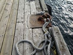 an old wooden dock with rope on it