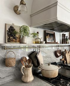 pots and pans are hanging on the wall above the stove