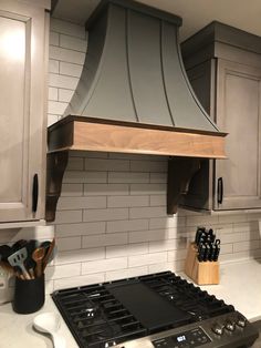 a stove top oven sitting inside of a kitchen next to white cabinets and counter tops