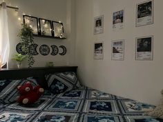 a bed with blue and white bedspread next to a window filled with pictures