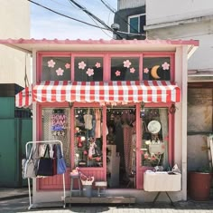 a scooter parked in front of a shop with pink and white awnings