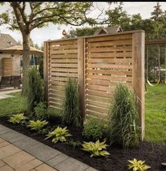 a wooden fence next to a lush green yard