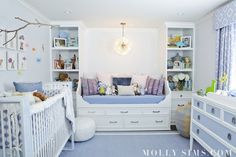 a baby's room with blue carpet and white furniture