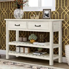 a white table with two drawers and some plants on it in front of a gold wallpaper