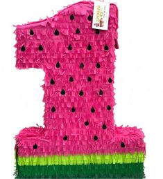 a pink and green number one made out of tissue paper with black dots on it