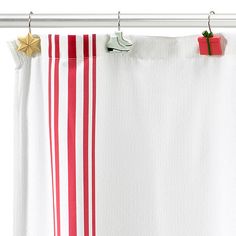 a red and white striped shower curtain hanging from a metal rod with star decorations on it