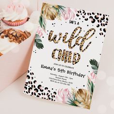 a pink box filled with cupcakes next to a card that says wild child