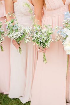 the bridesmaids are holding their bouquets with baby's breath in them