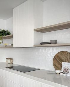 a kitchen with white cabinets and counter tops