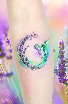 a tattoo on the leg of a woman with purple flowers and lavenders in the background