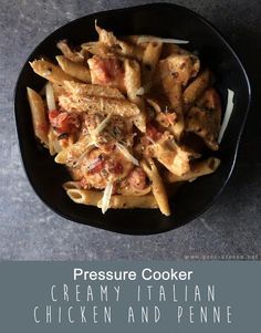 a black bowl filled with pasta covered in sauce