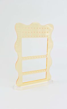 a white and yellow shelf with two shelves on each side, one has a mirror in the middle