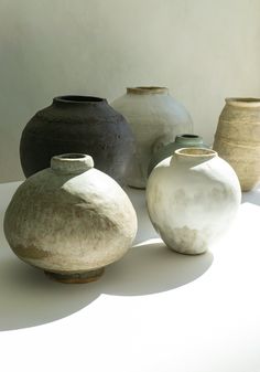 five vases are lined up on a white surface