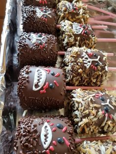 chocolate covered desserts are lined up on a tray with sticks sticking out of them