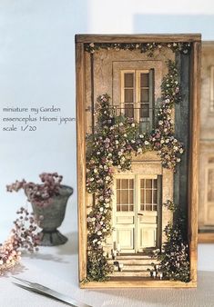 there is a miniature house with flowers on it