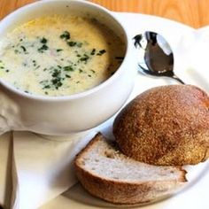 a bowl of soup next to a loaf of bread on a plate