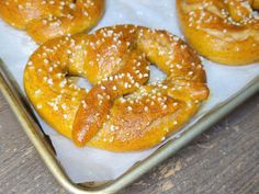 four bagels with sesame seeds are on a tray