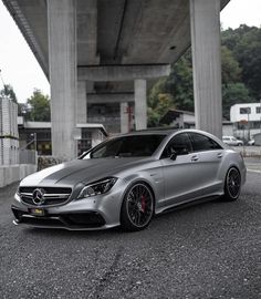 a silver mercedes cla parked under a bridge