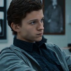 a young man sitting in front of a computer desk with his arm wrapped around the neck